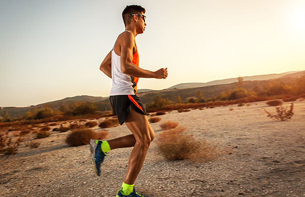 Young triathlon competitor runs over the desert.